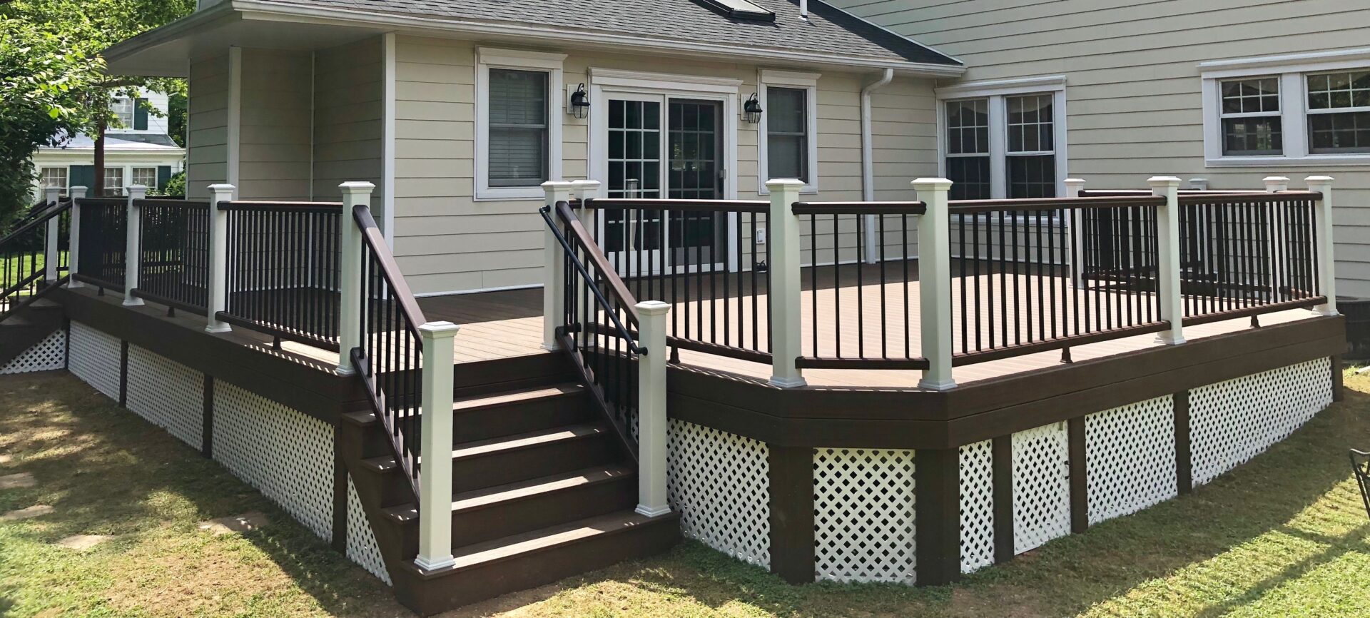 A deck with steps and stairs leading to the back of the house.